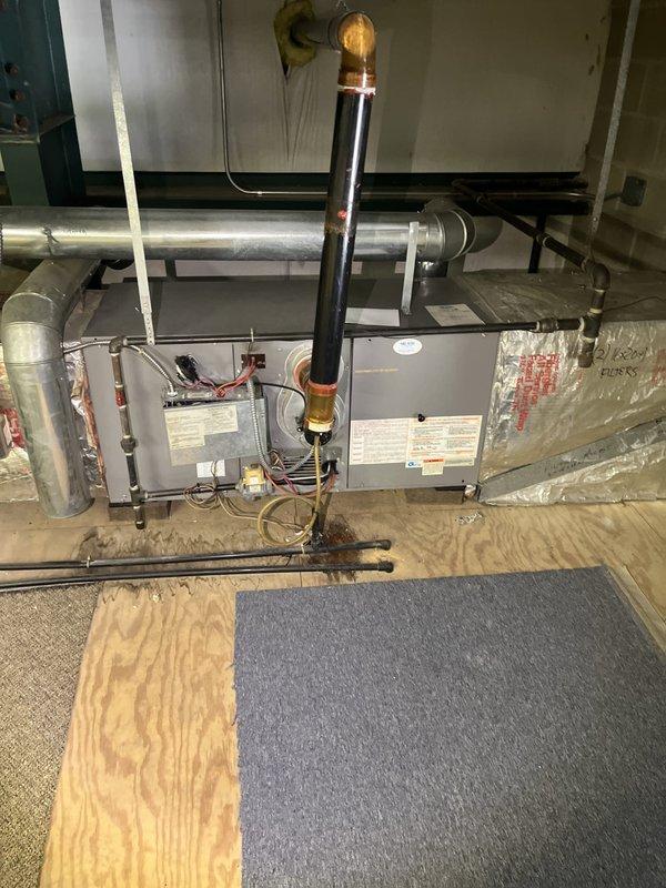 Conducted comprehensive assessment of existing commercial HVAC system for replacement estimate. Evaluated horizontal air handler unit mounted in utility space, including inspection of refrigerant lines, copper piping, brass fittings, filter-drier component, and electrical connections. Documented current system configuration with metallic ductwork, insulated refrigerant lines, and condensate drain routing. Photographed equipment specifications, existing installation conditions, and surrounding infrastructure to provide accurate replacement recommendations and system sizing requirements.