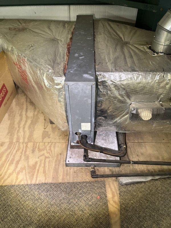 Conducted comprehensive assessment of existing commercial HVAC system for replacement estimate. Evaluated horizontal air handler unit mounted in utility space, including inspection of refrigerant lines, copper piping, brass fittings, filter-drier component, and electrical connections. Documented current system configuration with metallic ductwork, insulated refrigerant lines, and condensate drain routing. Photographed equipment specifications, existing installation conditions, and surrounding infrastructure to provide accurate replacement recommendations and system sizing requirements.