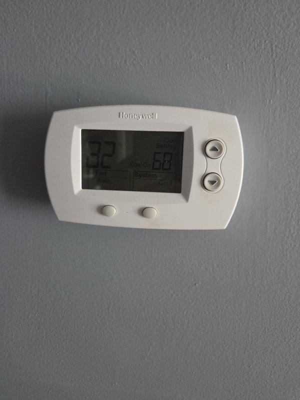 Conducted comprehensive evaluation of existing HVAC system for full replacement estimate. Assessed outdoor condensing unit with diamond-pattern grille positioned on concrete pad, noting copper refrigerant line routing and service port accessibility. Documented current Honeywell digital thermostat configuration and control system for replacement specifications.