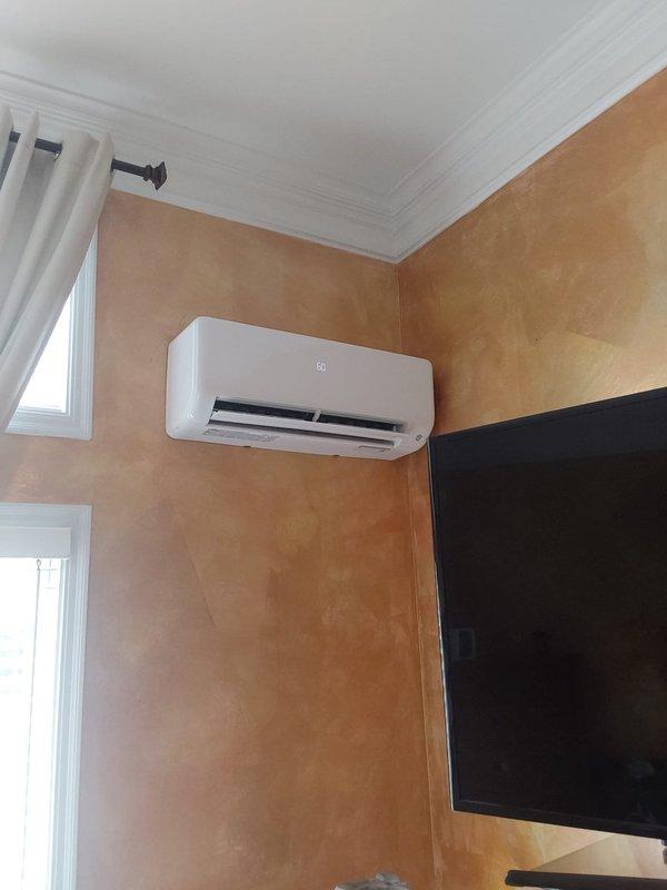 Completed full installation of Bryant single-zone ductless mini-split system consisting of model D5MAHAQ12XA3 indoor high-wall unit and model 37MAHAQ12AA3 outdoor condenser unit. Mounted outdoor condenser on foundation pad at exterior wall with proper clearances, installed electrical disconnect box on foundation wall, and ran black electrical conduit from unit to disconnect. Installed indoor air handler in upper corner of interior room with proper positioning for optimal air distribution. Ran refrigerant line set and electrical connections between indoor and outdoor units through exterior wall penetration. Completed all electrical connections, vacuum and pressure tested refrigerant lines, charged system to manufacturer specifications, and verified proper operation of all system functions including cooling performance and airflow.