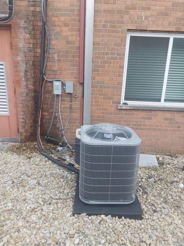 Completed full HVAC system installation including Bryant GA4SAN524 air conditioning unit relocated to ground level on rubber pad with gravel base, and BCRVMA2124S314 water fan coil unit installed in interior mechanical closet. Connected all refrigerant lines, installed new copper piping and fittings to existing water supply with brass valves and flexible connections, ran electrical conduit and wiring from exterior disconnect panel to condensing unit, completed all PVC and corrugated drain line connections, installed new programmable thermostat, pulled permit, and verified system operation with proper airflow and temperature differential.