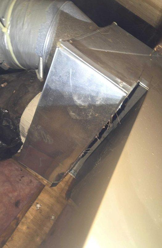Conducted comprehensive estimate for ductwork replacement in attic space. Inspected existing galvanized sheet metal Y-junction plenum connecting to flexible ductwork, noting dust accumulation and age-related wear on metal surfaces. Evaluated black flexible ducting with insulation showing deteriorated tape seals and assessed routing through confined crawl space areas with fiberglass insulation present. Documented current duct configuration including rigid circular transition fittings and rectangular plenum with visible seams for replacement specifications.
