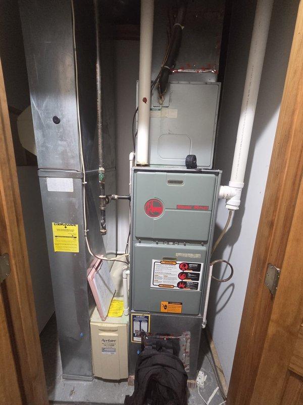 Conducted comprehensive assessment of existing residential HVAC system for complete replacement. Evaluated current equipment configuration including furnace, air handler, refrigerant lines, condensate drainage, and associated ductwork in basement utility space. Documented existing Classic 90 Plus furnace installation, copper refrigerant line routing with shutoff valves, PVC venting system, humidifier unit, gas piping connections, and electrical wiring configuration. Photographed equipment layout and spatial constraints to determine optimal replacement specifications and equipment sizing requirements for new system installation.