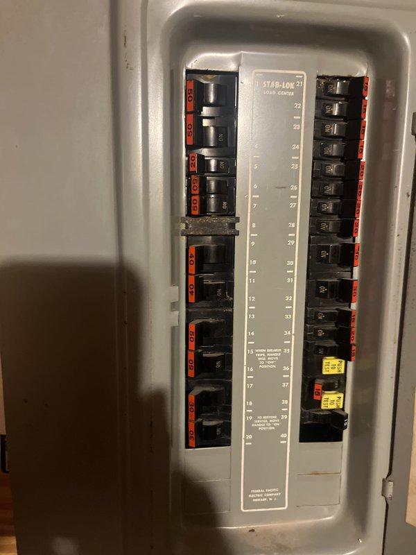 Provided estimate for complete heat pump system replacement of 1994 unit utilizing obsolete R22 refrigerant that is no longer adequately maintaining temperature. Existing outdoor condenser unit shows significant age-related deterioration with rust staining and weathering on cabinet panels, and electrical panel is Federal Pacific Stab-Lok series requiring updating to current safety standards.