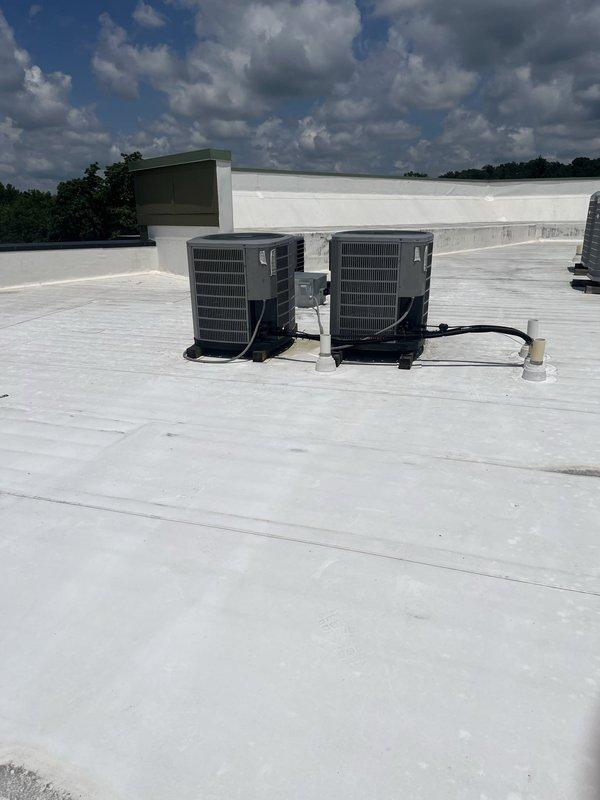 Conducted comprehensive site assessment of existing dual commercial rooftop HVAC units for replacement estimate. Documented current RTU configuration, refrigerant line routing, electrical connections, and rooftop conditions. Photographed electrical panel showing dedicated 30-amp circuits serving AC equipment to verify existing power supply specifications for replacement unit sizing and compatibility requirements.