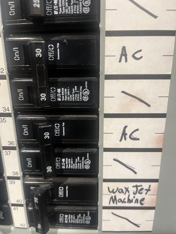 Conducted comprehensive site assessment of existing dual commercial rooftop HVAC units for replacement estimate. Documented current RTU configuration, refrigerant line routing, electrical connections, and rooftop conditions. Photographed electrical panel showing dedicated 30-amp circuits serving AC equipment to verify existing power supply specifications for replacement unit sizing and compatibility requirements.