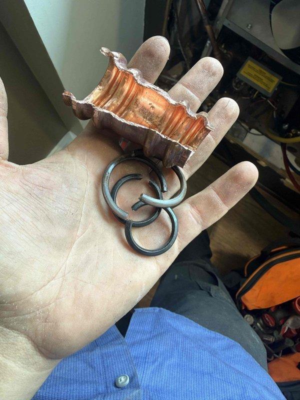 Responded to callback for leak at press fitting connection on refrigerant lines. Upon inspection, identified failed O-ring seals and corroded copper press fitting causing refrigerant leak. Removed defective press fitting and deteriorated O-rings from system. Installed new press fitting with fresh O-ring seals on copper refrigerant lines. Verified all connections were secure and leak-free. System tested and confirmed operating properly with no further leaks detected.