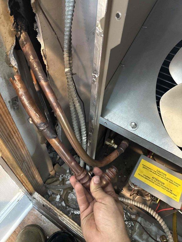 Responded to callback for leak at press fitting connection on refrigerant lines. Upon inspection, identified failed O-ring seals and corroded copper press fitting causing refrigerant leak. Removed defective press fitting and deteriorated O-rings from system. Installed new press fitting with fresh O-ring seals on copper refrigerant lines. Verified all connections were secure and leak-free. System tested and confirmed operating properly with no further leaks detected.