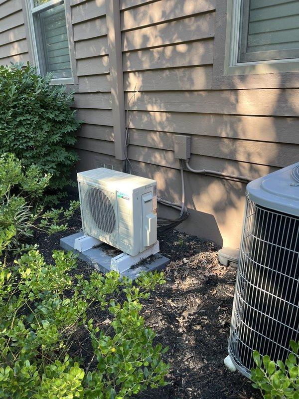 Completed estimate for additional mini-split system to supplement existing HVAC equipment. Evaluated current electrical panel capacity and confirmed available breaker space for new installation. Assessed exterior location adjacent to existing white mini-split condenser and traditional AC unit, both positioned on concrete pads with proper clearances. Provided recommendations for adding zone to current mini-split system including equipment specifications, electrical requirements, and installation parameters.