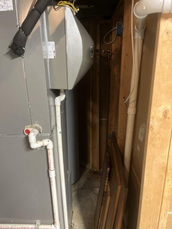 Conducted comprehensive assessment of existing residential air conditioning system for replacement estimate. Evaluated outdoor condensing unit with protective cage positioned on exterior foundation alongside landscaping and inspected indoor air handler unit located in utility space with associated ductwork, refrigerant lines, condensate drainage system with PVC piping, and electrical connections. Documented current equipment configuration, installation conditions, and spatial constraints to provide accurate replacement recommendations and specifications.