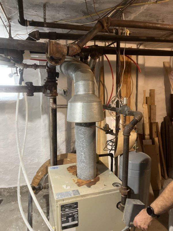 Conducted on-site assessment for replacement of existing boiler system with new wall-mounted high-efficiency unit. Evaluated existing hydronic heating infrastructure including legacy cast-iron radiators, two aluminum radiators, and radiant floor heating zone requiring temperature mixing. Documented current boiler installation, aged cast-iron piping configuration showing signs of corrosion, and existing primary pumping arrangement. Developed specifications for new system requiring primary/secondary pumping design to accommodate multiple heating zones with varying temperature requirements. Provided estimate for complete boiler removal, installation of wall-mounted condensing boiler, simplification of distribution piping with new manifold system, and integration of temperature control for radiant floor application.