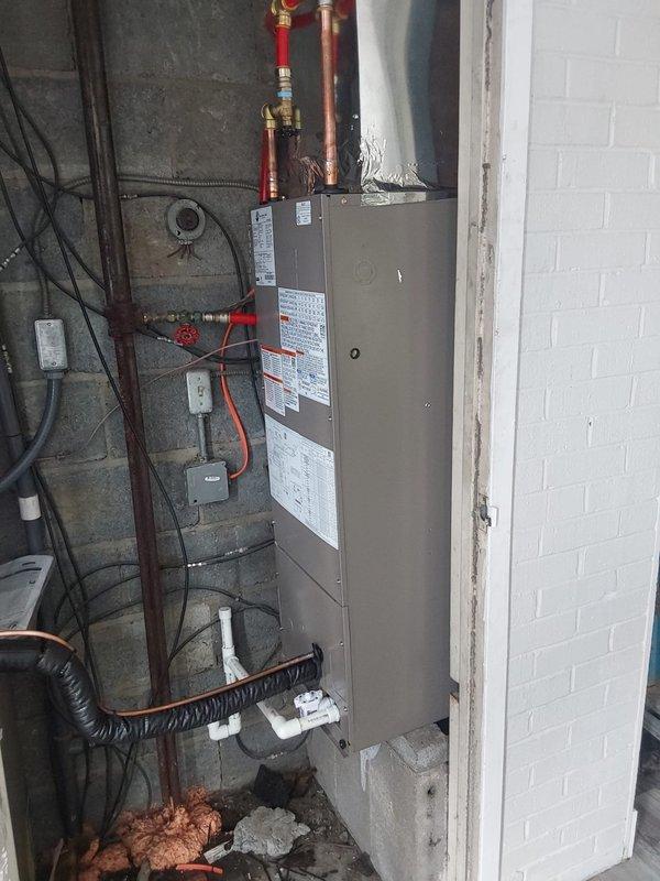Completed full HVAC system installation for commercial property including Bryant GA4SAN524 air conditioning condensing unit relocated to ground level and BCRMA2124S3N3 water fan coil unit. Installed new refrigerant lineset with proper insulation, ran electrical conduit and wiring along exterior brick wall with junction boxes, and connected copper supply piping to existing water lines with shutoff valves. Positioned both outdoor condensing units on gravel pad with proper clearances, secured all refrigerant lines and electrical connections per manufacturer specifications, installed new programmable thermostat, and completed all work under proper permit. System tested, charged to specifications, and verified operational.