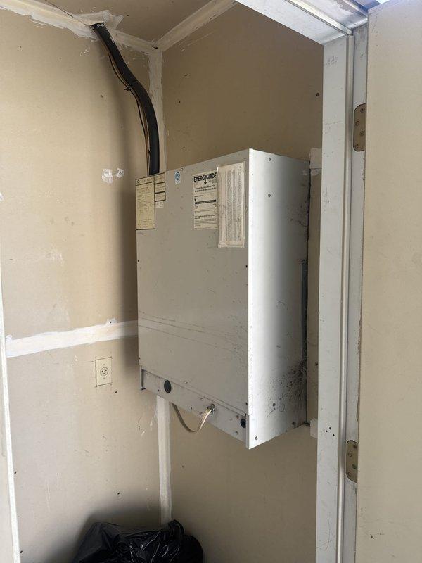 Responded to service call for refrigerant leak on commercial air conditioning unit. Upon arrival, located air handler in utility closet and performed visual inspection of system components. Documented equipment condition and electrical panel configuration showing furnace and range circuits with proper breaker protection in place.