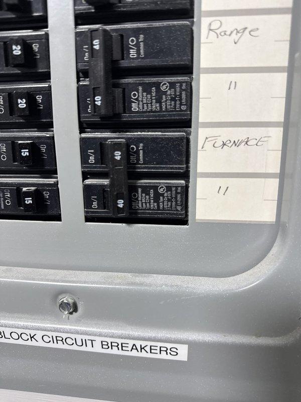 Responded to service call for refrigerant leak on commercial air conditioning unit. Upon arrival, located air handler in utility closet and performed visual inspection of system components. Documented equipment condition and electrical panel configuration showing furnace and range circuits with proper breaker protection in place.