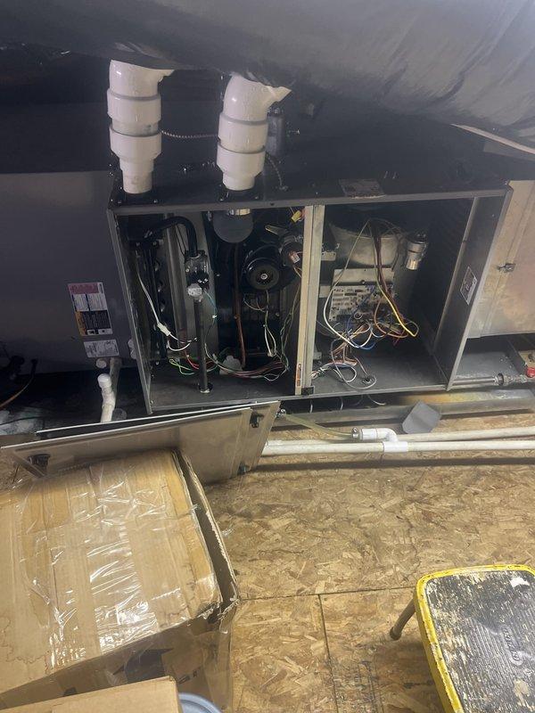 Performed commercial HVAC system evaluation at attic-mounted air handler installation. Inspected internal components including blower motors, control boards, wiring harnesses, and condensate drainage system with multiple PVC discharge lines. Evaluated electrical service at main breaker panel to assess capacity for potential equipment replacement and documented existing system configuration for replacement estimate preparation.