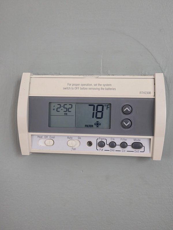 Conducted on-site assessment of existing HVAC system for air conditioning replacement estimate. Documented current equipment configuration including digital programmable thermostat (RTH230B model) and electrical panel with Challenger breaker system. Captured photographic documentation of existing components to support replacement proposal and system specifications.