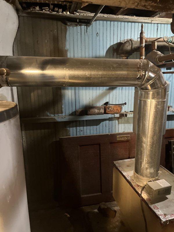 Conducted comprehensive evaluation of existing Lochinvar boiler system including heating load calculations and inspection of current installation configuration. Assessed oil-fired burner assembly, expansion tank, ductwork distribution system, and associated piping connections to determine replacement specifications and system requirements. Documented equipment conditions and spatial constraints in mechanical room to provide accurate recommendations for new boiler installation.