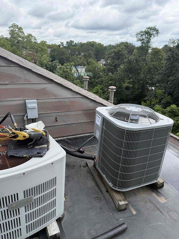 Completed commercial rooftop HVAC installation featuring two Bryant 2-ton systems: primary GA4SAN524 14 SEER condenser with R454 refrigerant paired with CVAVA2414 evaporator coil, plus additional GA4SAN52400 condenser unit. Flushed and reused existing refrigerant lines, installed outdoor disconnect and whip, and properly disposed of old equipment per EPA regulations. Both units mounted on roof with appropriate support, systems commissioned and verified operational with temperature readings confirming proper performance.