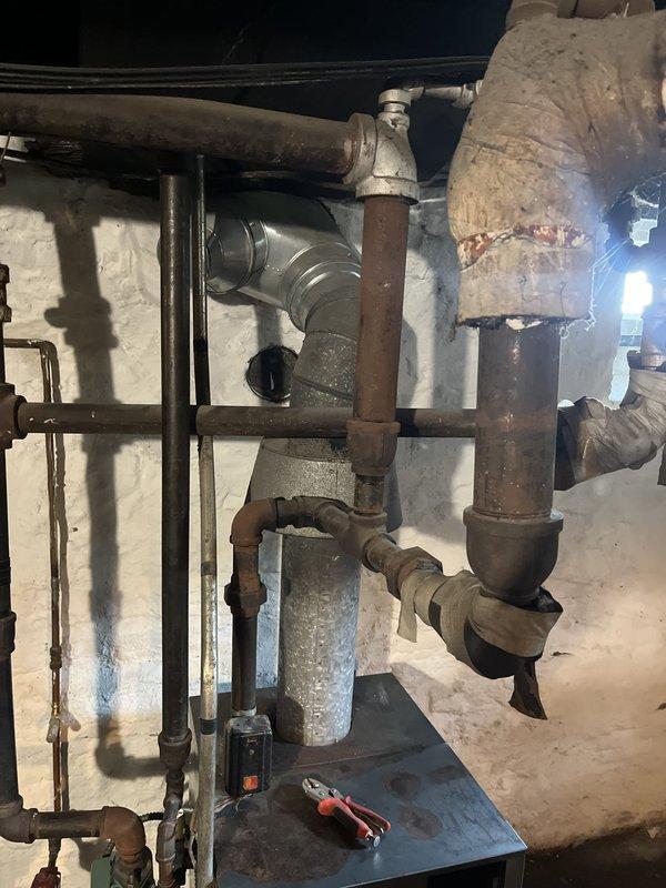 Conducted comprehensive on-site evaluation of aging 1980s-era boiler system and associated hydronic heating components. Documented existing equipment condition, noting significant corrosion on metal piping, deteriorated insulation wrapping on ductwork, and overall system age requiring replacement consideration. Provided detailed estimate for complete boiler system replacement including all necessary connections, venting, and integration with existing water heater and distribution piping.