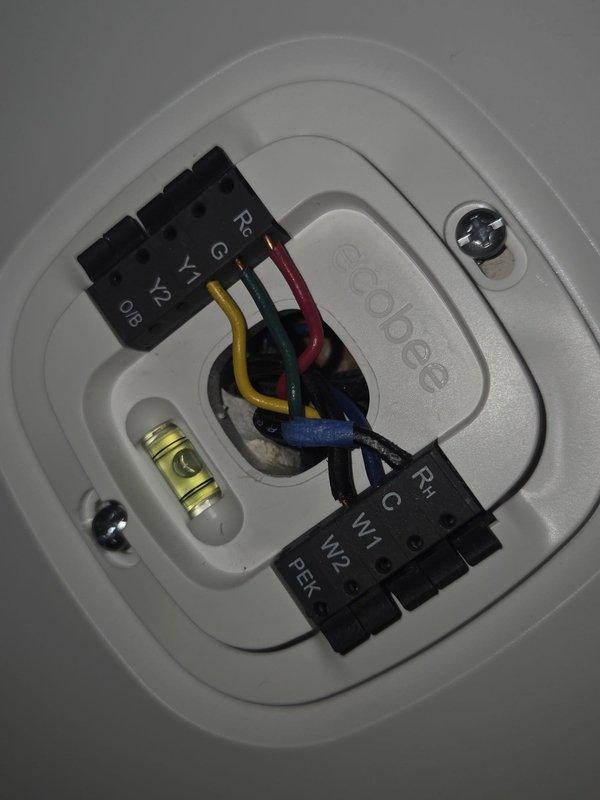 Conducted comprehensive site evaluation for complete HVAC system replacement. Assessed existing outdoor condenser unit and indoor thermostat configuration. Documented current system specifications including ecobee thermostat with power extender kit (PEK) wiring, multi-stage heating and cooling connections, and outdoor condensing unit with electrical disconnect. Photographed equipment placement, refrigerant line routing through exterior brick wall, and existing pad location. Provided customer with replacement options and system recommendations based on current installation parameters.