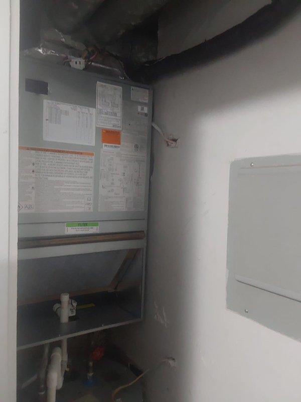 Removed existing through-wall HVAC unit and completed full system replacement with Bryant GA5SAN52400 2-ton 15 SEER air conditioning condenser utilizing R454B refrigerant, relocated and installed on ground-level concrete pad. Installed Bryant FMA5X24 air handler with 5kW heat strip in interior utility closet. Fabricated and installed custom sheet metal transitions to connect new air handler to existing supply and return ductwork. Flushed existing lineset to remove contaminants and ensure system compatibility with new R454B refrigerant. Installed electrical disconnect, whip, and fuses to provide proper power supply and overcurrent protection for outdoor condenser unit. Mounted condenser on equipment pad per manufacturer specifications. Pulled permit for installation and ensured all work met local building codes and manufacturer requirements. Properly recovered refrigerant from old equipment and disposed of existing system components in accordance with EPA regulations. System startup com