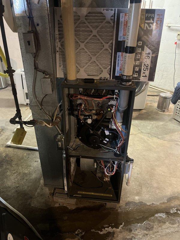 Completed comprehensive assessment of existing HVAC system for full replacement estimate due to equipment age. Evaluated indoor furnace unit located in basement with access panel removed to inspect internal components including blower assembly, heat exchanger, control board, wiring harnesses, and copper refrigerant lines. Assessed outdoor air conditioning condenser unit positioned between building exterior walls, noting weathered condition and operational status. Documented current system configuration including ductwork connections, electrical service, filter rack setup with 16x25x1 filter size, and refrigerant line routing. Provided detailed replacement recommendations for both heating and cooling equipment to address age-related concerns and ensure continued reliable operation.