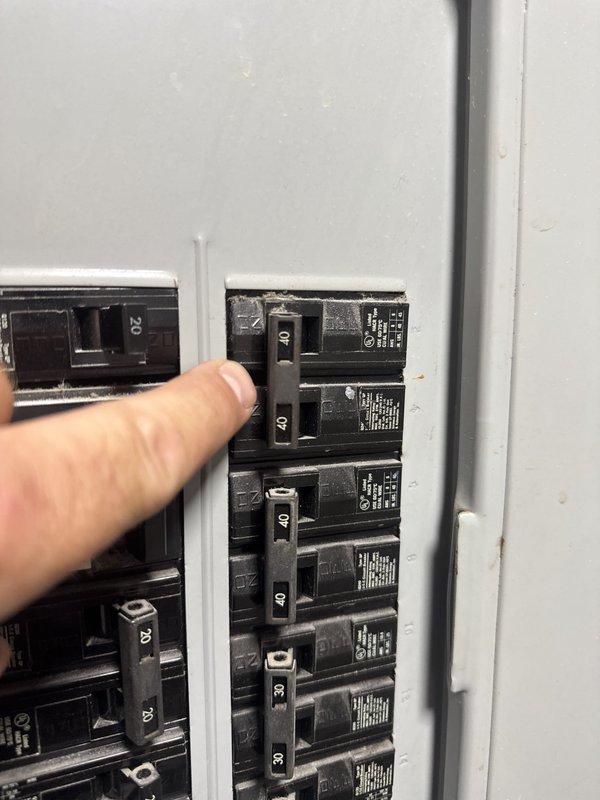 Responded to no cooling call at commercial property. Upon arrival, located HVAC equipment in utility closet and inspected electrical system. Found tripped circuit breaker at electrical panel serving the air conditioning unit. Reset breaker and verified power restoration to system. Unit resumed normal operation and cooling was restored.