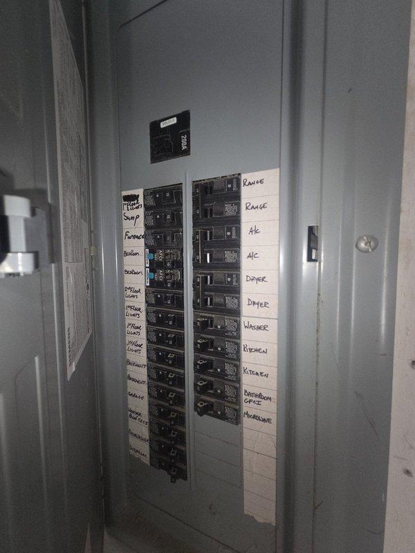 Performed comprehensive estimate for complete HVAC system replacement of air conditioning unit and gas furnace, both exceeding 20 years of service life. Documented existing electrical panel configuration showing dedicated circuits for HVAC equipment and photographed thermostat wiring connections at base plate to assess compatibility requirements for new system installation.