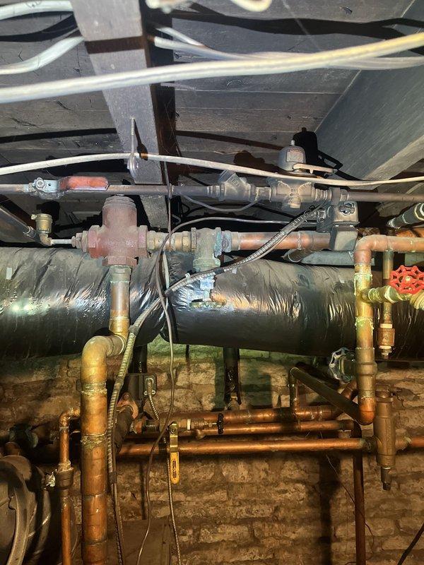 Conducted comprehensive assessment of existing boiler system and associated mechanical infrastructure in basement utility space. Documented current equipment configuration including copper piping, ductwork, insulation condition, and HVAC components to provide detailed replacement estimate for aging boiler system.