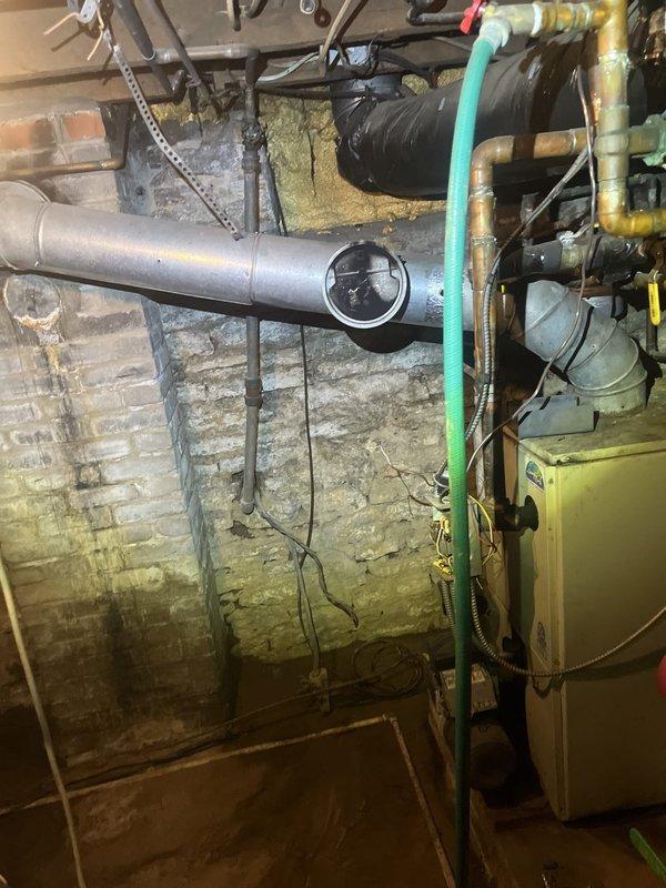 Conducted comprehensive assessment of existing boiler system and associated mechanical infrastructure in basement utility space. Documented current equipment configuration including copper piping, ductwork, insulation condition, and HVAC components to provide detailed replacement estimate for aging boiler system.