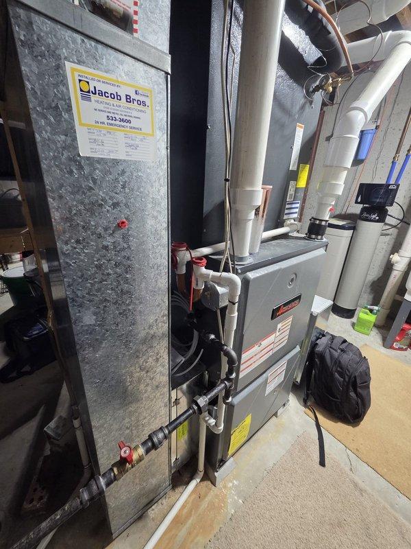 Completed estimate for complete HVAC system replacement in residential basement mechanical room. Evaluated existing furnace, air handler, and humidifier system for replacement, noting current configuration includes gray furnace unit with integrated air handler, mounted humidifier with electronic controls, PVC condensate drainage and venting system, insulated ductwork, and copper refrigerant lines. Documented existing equipment specifications and installation requirements for proposed system upgrade.