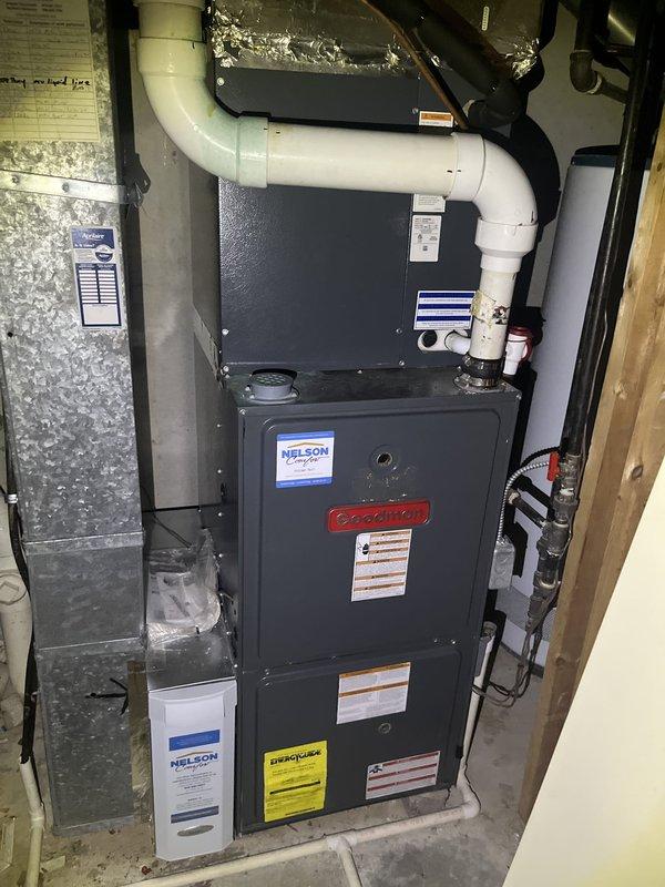 Conducted comprehensive assessment of existing residential HVAC system in basement utility room for equipment replacement estimate. Evaluated aging Goodman furnace unit showing visible wear, dust accumulation, and operational age concerns. Documented current system configuration including PVC venting arrangement, condensate drainage piping, copper water lines, return air ductwork, electrical disconnect components, and silver flex ductwork connections. Photographed existing furnace specifications, manufacturer labels, efficiency ratings, and overall installation layout to provide accurate replacement recommendations and system sizing requirements for complete furnace changeout.