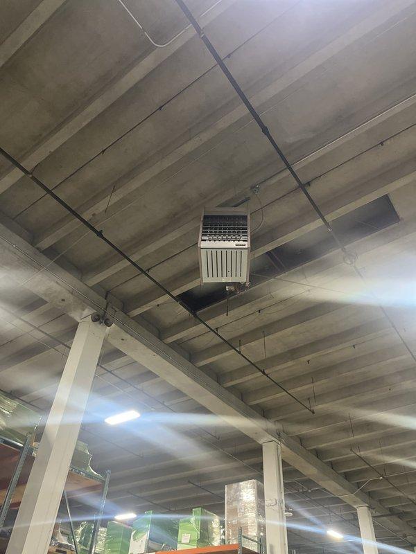 Conducted comprehensive site evaluation of multiple suspended heating units in commercial warehouse facility. Assessed ceiling-mounted HVAC equipment including evaporative cooling systems and heating units serving high-bay storage areas. Documented existing equipment conditions, configurations, and mounting systems for preparation of heating system replacement estimate.