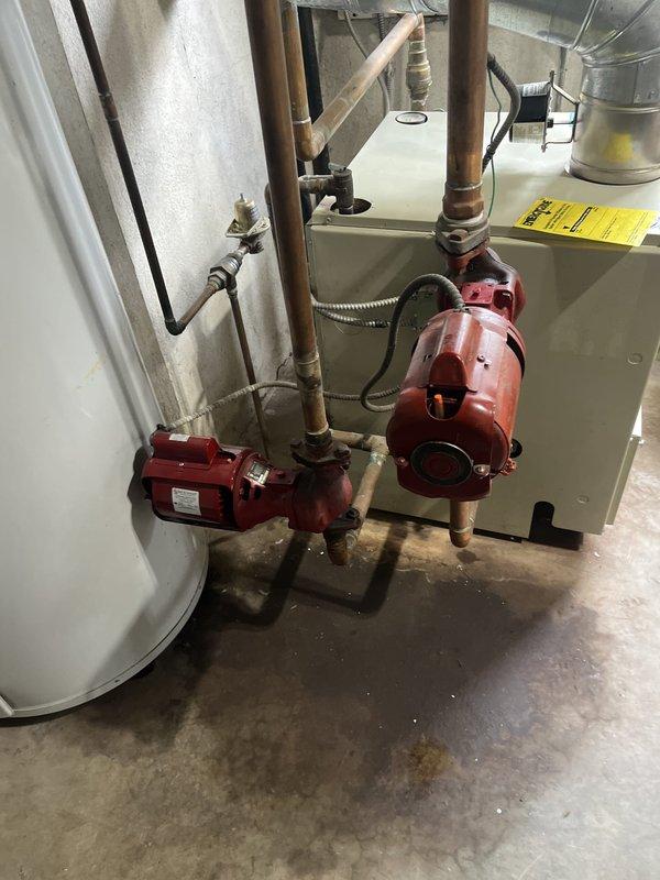 Conducted comprehensive estimate for replacement of 28-year-old HVAC system including outdoor air conditioning unit and indoor boiler with circulation pumps. Documented existing equipment condition through photographs showing aged copper piping with natural patina, multiple red circulation pumps, water heater/boiler unit, and outdoor condenser unit with functional louvers and grille, all systems currently operational but at end of expected service life.