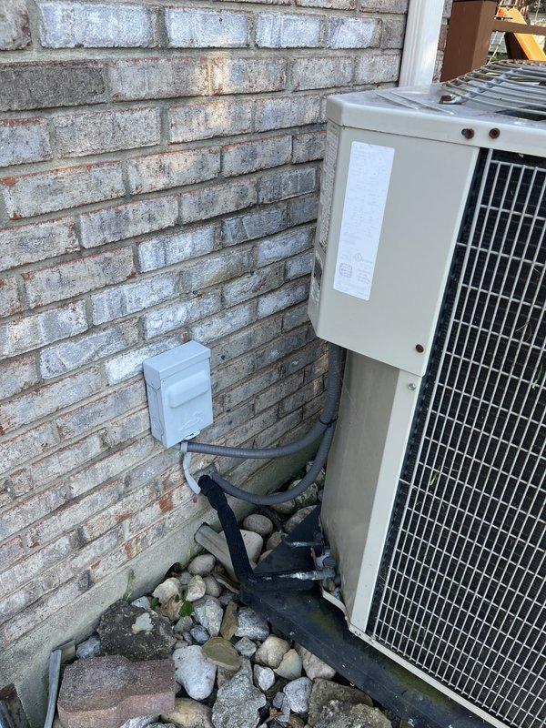 Performed an on-site assessment for replacement of the existing residential split-system air conditioning condenser, inspecting the unit, data plate, electrical disconnect, flexible conduit, and refrigerant line set. Observed surface corrosion on the fan guard and fasteners, weathering on the cabinet, and moss growth on the equipment pad. Documented the installation with photos to support replacement system sizing and recommendations.