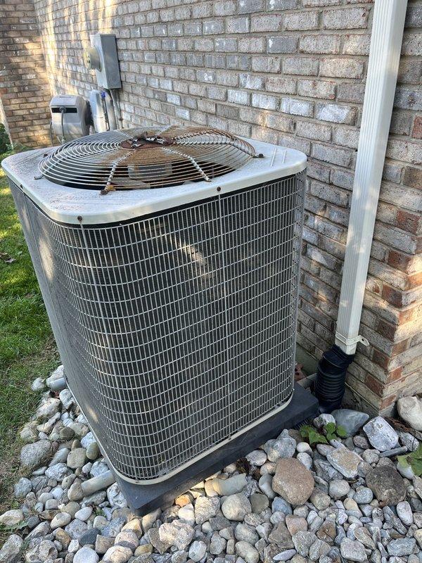 Performed an on-site assessment for replacement of the existing residential split-system air conditioning condenser, inspecting the unit, data plate, electrical disconnect, flexible conduit, and refrigerant line set. Observed surface corrosion on the fan guard and fasteners, weathering on the cabinet, and moss growth on the equipment pad. Documented the installation with photos to support replacement system sizing and recommendations.