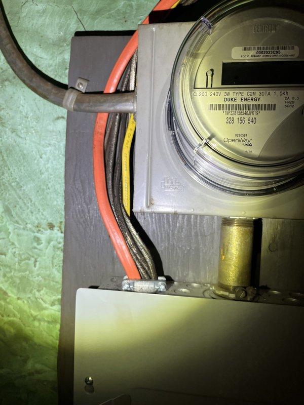 Performed an on-site evaluation for additional HVAC work following a recently completed system installation, documenting existing conditions for a replacement estimate. Inspected the galvanized spiral ductwork and branch connections, noting worn, frayed duct insulation wrap, along with adjacent refrigerant and condensate piping in the mechanical space. Also assessed the electrical service, including the meter socket, conduit, and sub-panel enclosure, to verify power supply conditions for the proposed equipment, with no significant damage observed.