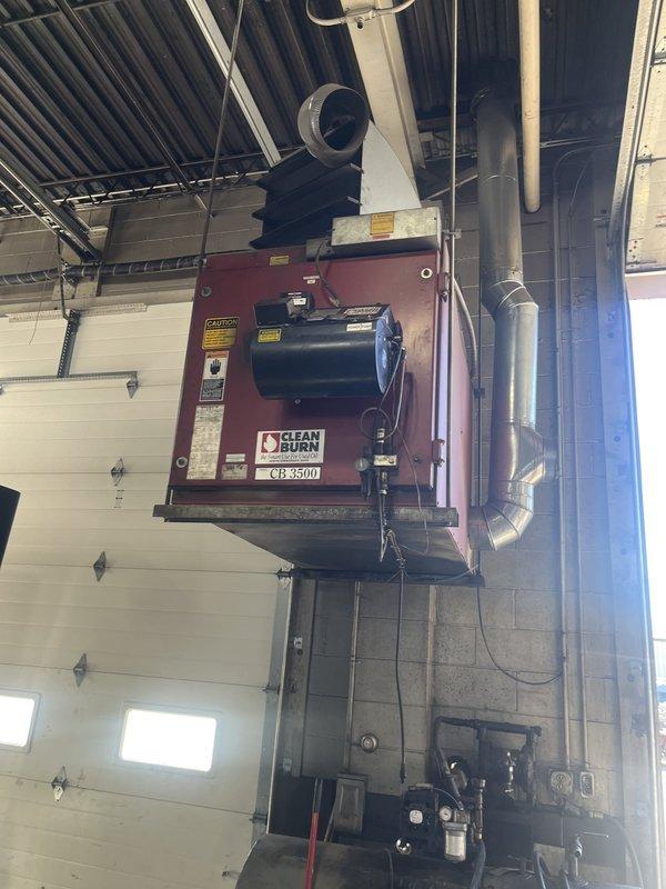 Performed an on-site estimate for replacement of a ceiling-mounted, oil-fired unit heater (Clean Burn CB 3500) located in a commercial maintenance shop. Inspected the unit, burner assembly, flue connection, ductwork, and associated piping and electrical conduit, and documented existing conditions with photographs to support replacement scoping. The unit showed general wear and dust accumulation, with no evidence of major corrosion or damage.