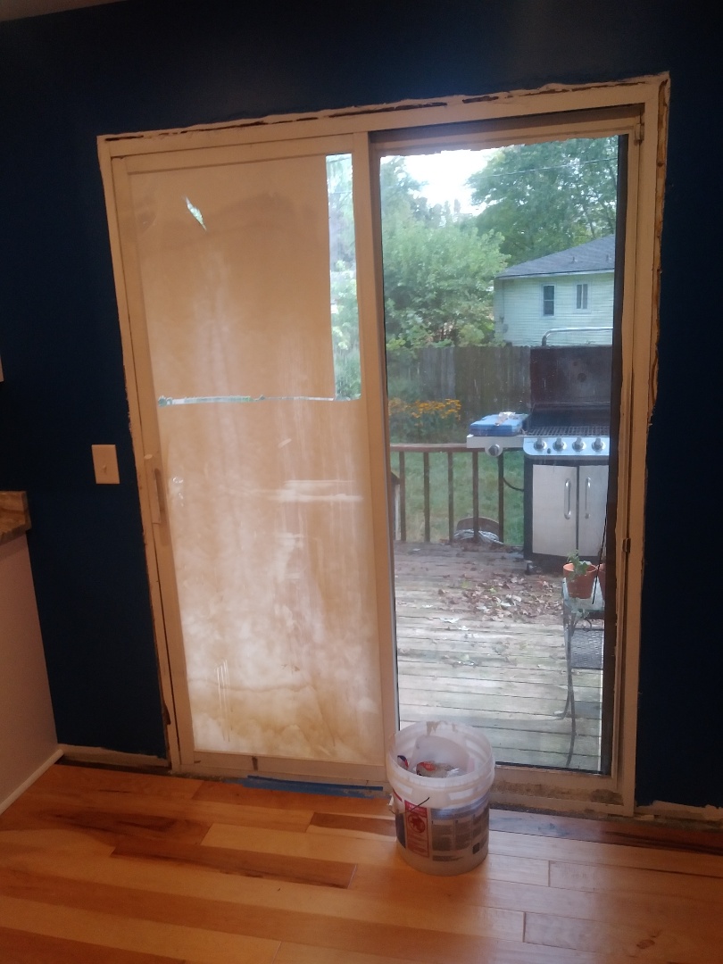 Walker, MI - The new doors and window are delayed so I'm scraping off the seal coating off the glass so the homeowners don't feel like they are living in an underground bunker Walker, MI - The new doors and window are delayed so I'm scraping off the seal coating off the glass so the homeowners don't feel like they are living in an underground bunker