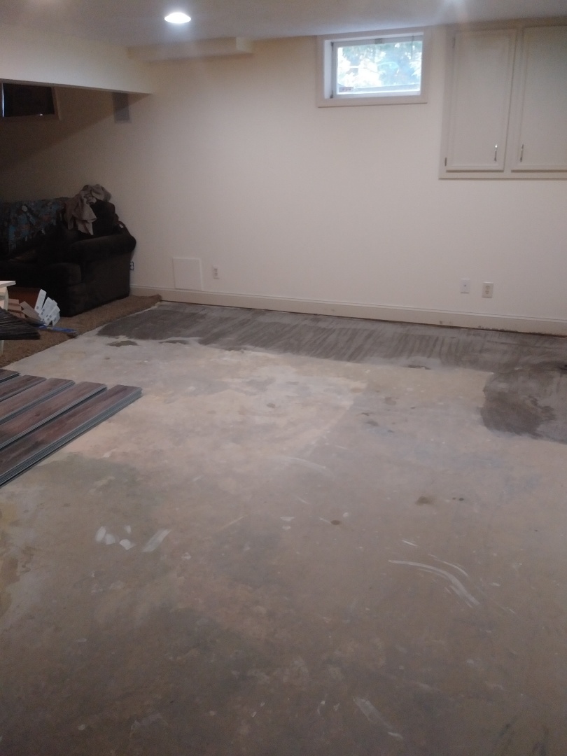 Hudsonville, MI - The prep work for the new vinyl plank is done. Tack strips, cement nails, carpet glue and pad remnants have been removed. Drywall mud has been scraped off the cement floor. There had been a previous floor repair and the cement patch was choppy and uneven. So I applied a considerable amount of floor leveled. It's ultra fast drying so I can start laying the vinyl plank shortly. Hudsonville, MI - The prep work for the new vinyl plank is done. Tack strips, cement nails, carpet glue and pad remnants have been removed. Drywall mud has been scraped off the cement floor. There had been a previous floor repair and the cement patch was choppy and uneven. So I applied a considerable amount of floor leveled. It's ultra fast drying so I can start laying the vinyl plank shortly.