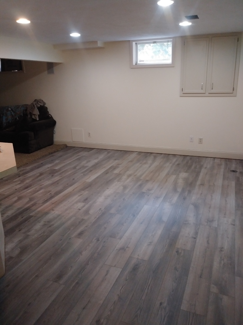 Hudsonville, MI - Finished the vinyl plank floor in the basement living room. Even spray painted the white drain clean-out on the floor to match the planks. Hudsonville, MI - Finished the vinyl plank floor in the basement living room. Even spray painted the white drain clean-out on the floor to match the planks.