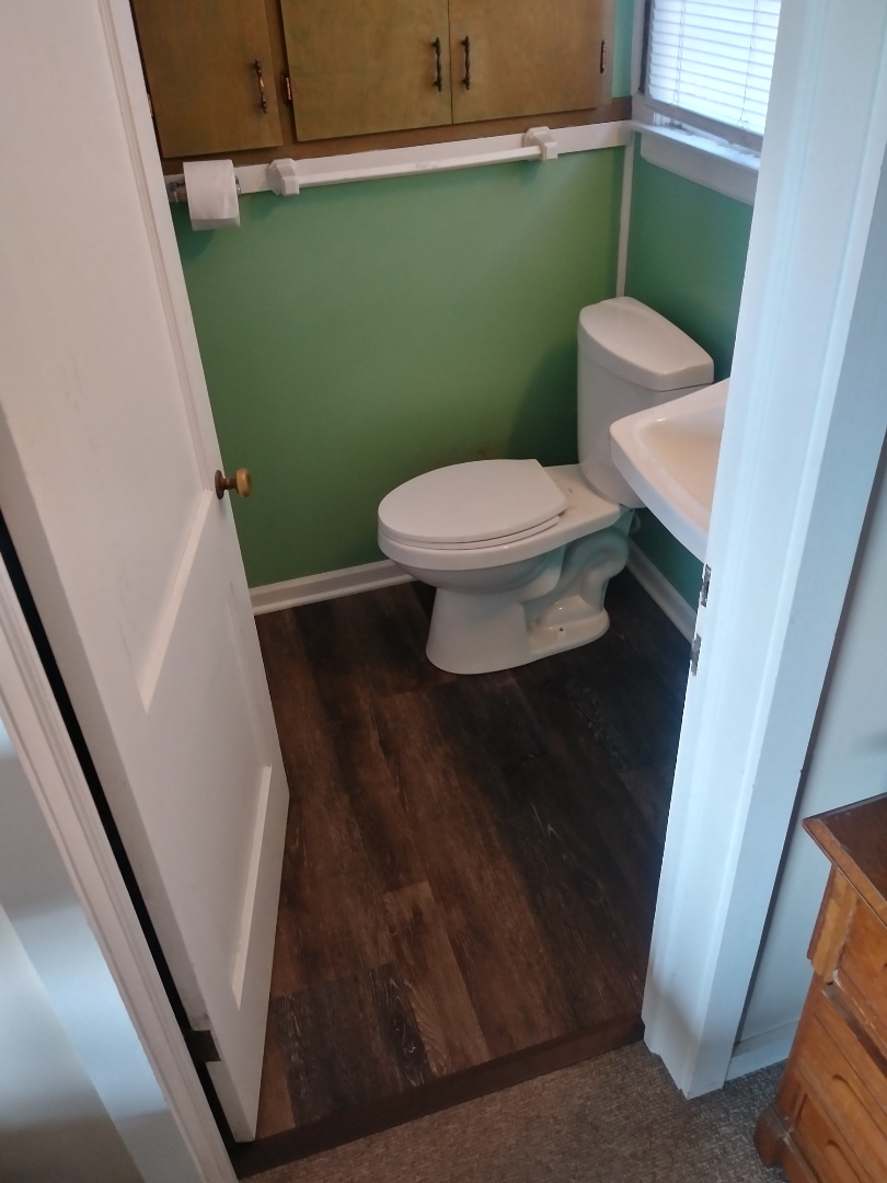 Caledonia, MI - The new vinyl plank floor installed at a cottage. Replaced the shoe molding. Added trim in front of the shower. Installed transition strip. Also had to cut the door down. Caledonia, MI - The new vinyl plank floor installed at a cottage. Replaced the shoe molding. Added trim in front of the shower. Installed transition strip. Also had to cut the door down.