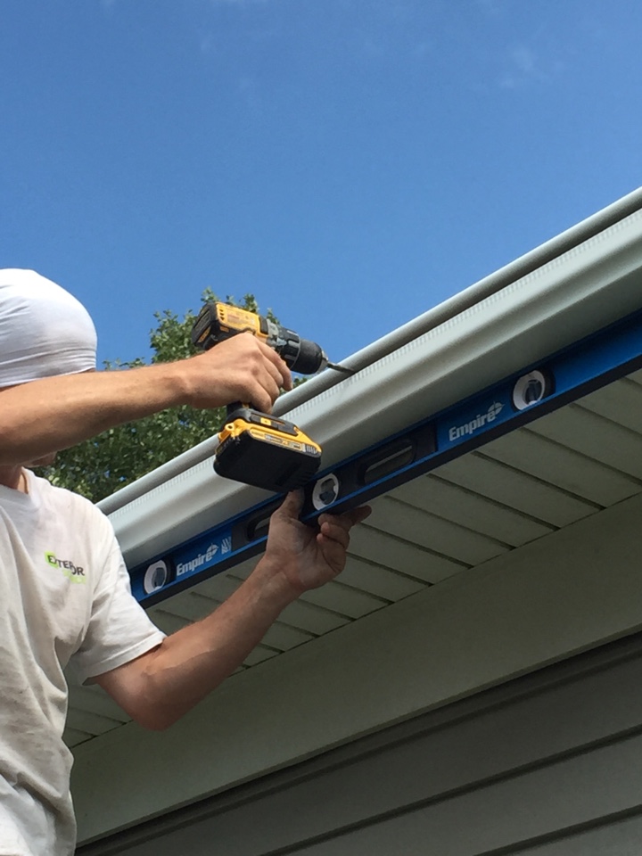 Chesapeake, VA - Checking the slope and securing the LeafGuard gutters to the fascia boards. Chesapeake, VA - Checking the slope and securing the LeafGuard gutters to the fascia boards.