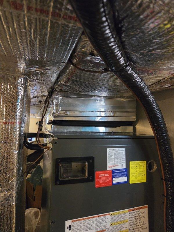 Returned to site to inspect HVAC system installation issues identified during previous visit. Found supply plenum improperly attached to air handler with significant air leakage causing duct wrap inflation—flex collar connection should have been installed between duct system and air handler to prevent air escape. Discovered exposed high-voltage electrical wiring terminated with wire nuts and electrical tape while breaker remained energized, creating immediate safety hazard. Identified undersized heat kit installed compared to original equipment specifications. Documented all findings with photographic evidence and recommended immediate correction of plenum connection, proper electrical termination with breaker de-energization during work, and replacement with appropriately sized 15 kW or 20 kW heat kit to match system heating requirements.