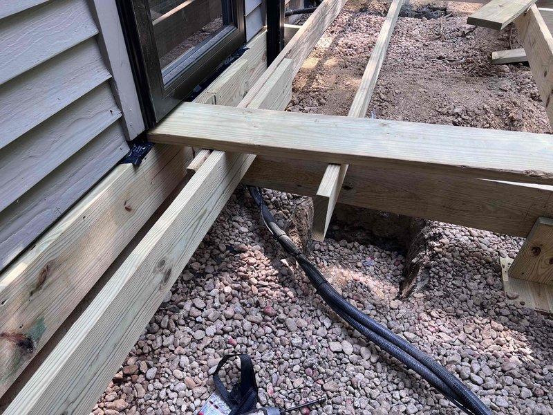 Installed structural anchors and support straps to secure deck framing to exterior wall per management specifications. Verified proper attachment of pressure-treated lumber framework to building structure using metal brackets and fasteners. Inspected crawl space and attic areas to assess structural connections and documented installation with photographic evidence.