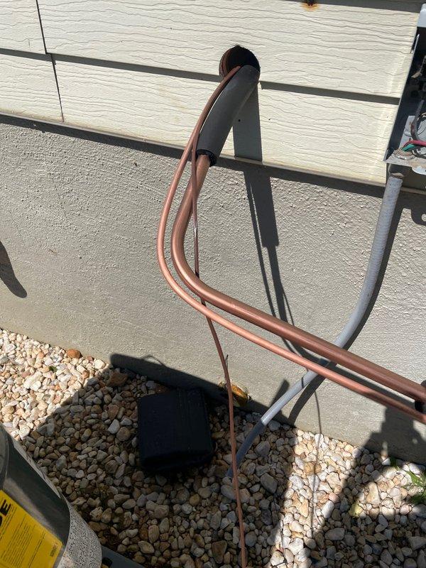 Completed full HVAC system installation including Goodman furnace unit in basement mechanical room and outdoor condensing unit on rooftop. Installed copper refrigerant line set with proper insulation running from rooftop equipment to indoor unit, secured linesets with appropriate bends and routing through gravel pad on roof surface. Mounted furnace with proper clearances from walls, connected white PVC condensate drain lines and black supply ductwork to unit, verified all manufacturer labels and safety placards visible and intact for future reference.