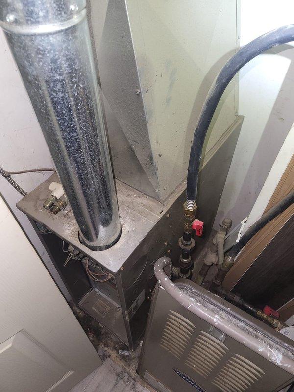 Completed comfort call inspection of residential HVAC system. Documented air handler unit in mechanical closet showing normal condensation on refrigerant lines and supply ductwork, indicating proper system operation in cooling mode. Inspected attic ductwork installation and verified flexible supply duct routing and insulation integrity throughout accessible areas of the home.