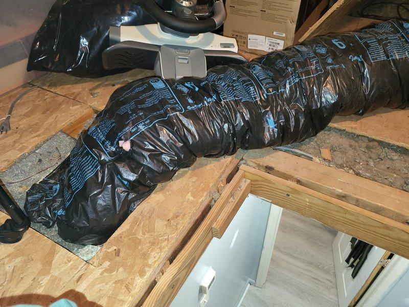 Completed comfort call inspection of residential HVAC system. Documented air handler unit in mechanical closet showing normal condensation on refrigerant lines and supply ductwork, indicating proper system operation in cooling mode. Inspected attic ductwork installation and verified flexible supply duct routing and insulation integrity throughout accessible areas of the home.