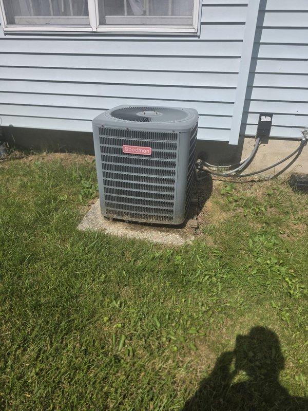 Completed comfort call inspection on Goodman brand outdoor condensing unit. Performed visual assessment of equipment condition, verified unit accessibility, and documented system configuration including refrigerant line routing and electrical disconnect placement. Unit shows normal weathering consistent with outdoor installation, with all major components accessible for service. Equipment operational parameters and manufacturer specifications photographed for service records.