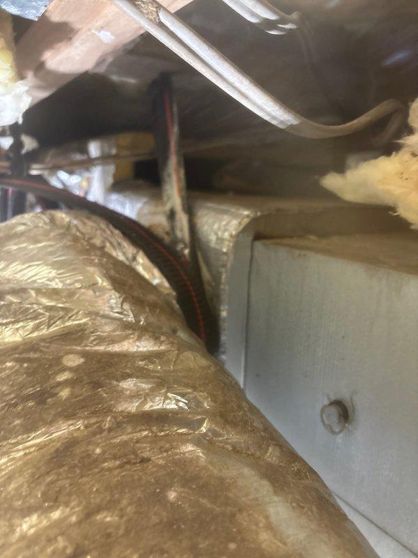 Responded to callback for HVAC system performance concerns. Upon inspection in attic space, discovered severely deteriorated flexible aluminum ductwork with extensive tears and shredding of outer metallic layer, exposing inner insulation material. Documented damaged sections showing compromised air distribution system integrity. Additional HVAC components including air handler unit, properly insulated supply ducts, and electrical wiring inspected and photographed for customer records and recommended repairs.